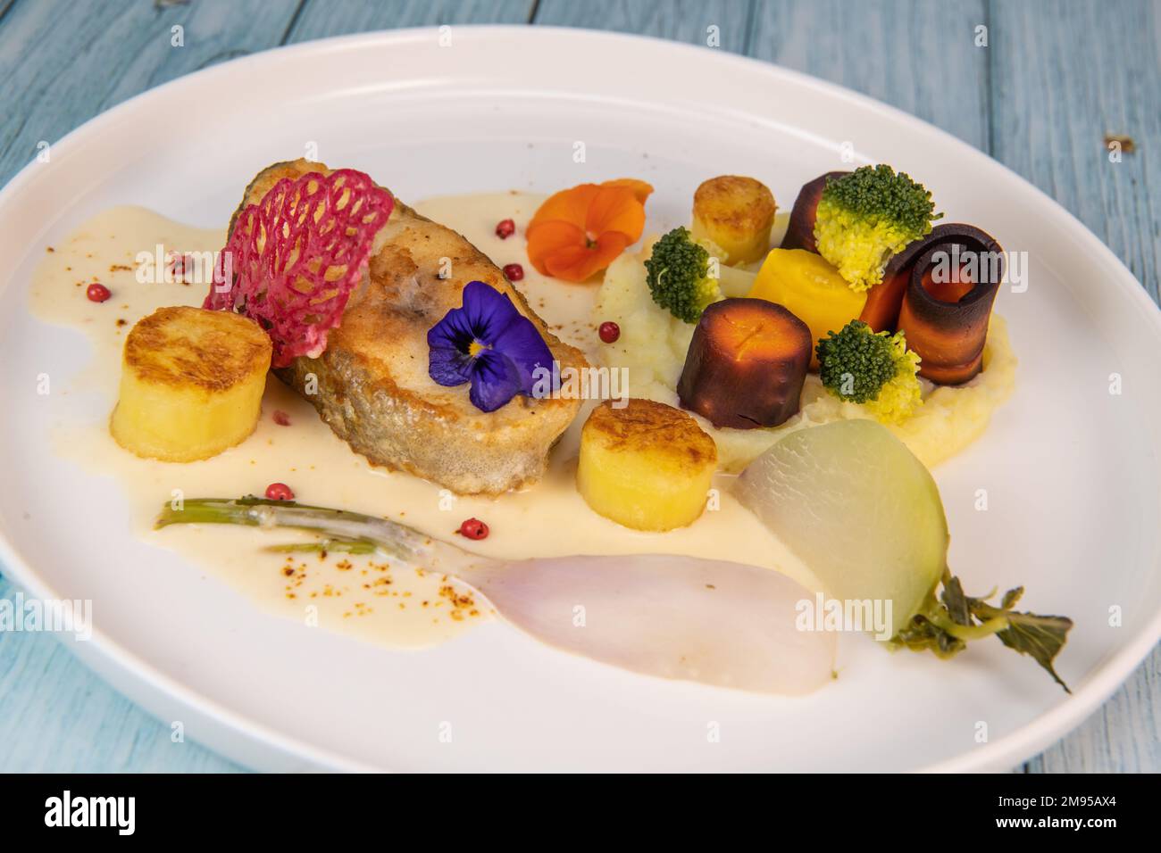 Recipe of cod steak, mashed potatoes and its farandole of vegetables, parsnip, turnip, broccoli, candied potato Stock Photo