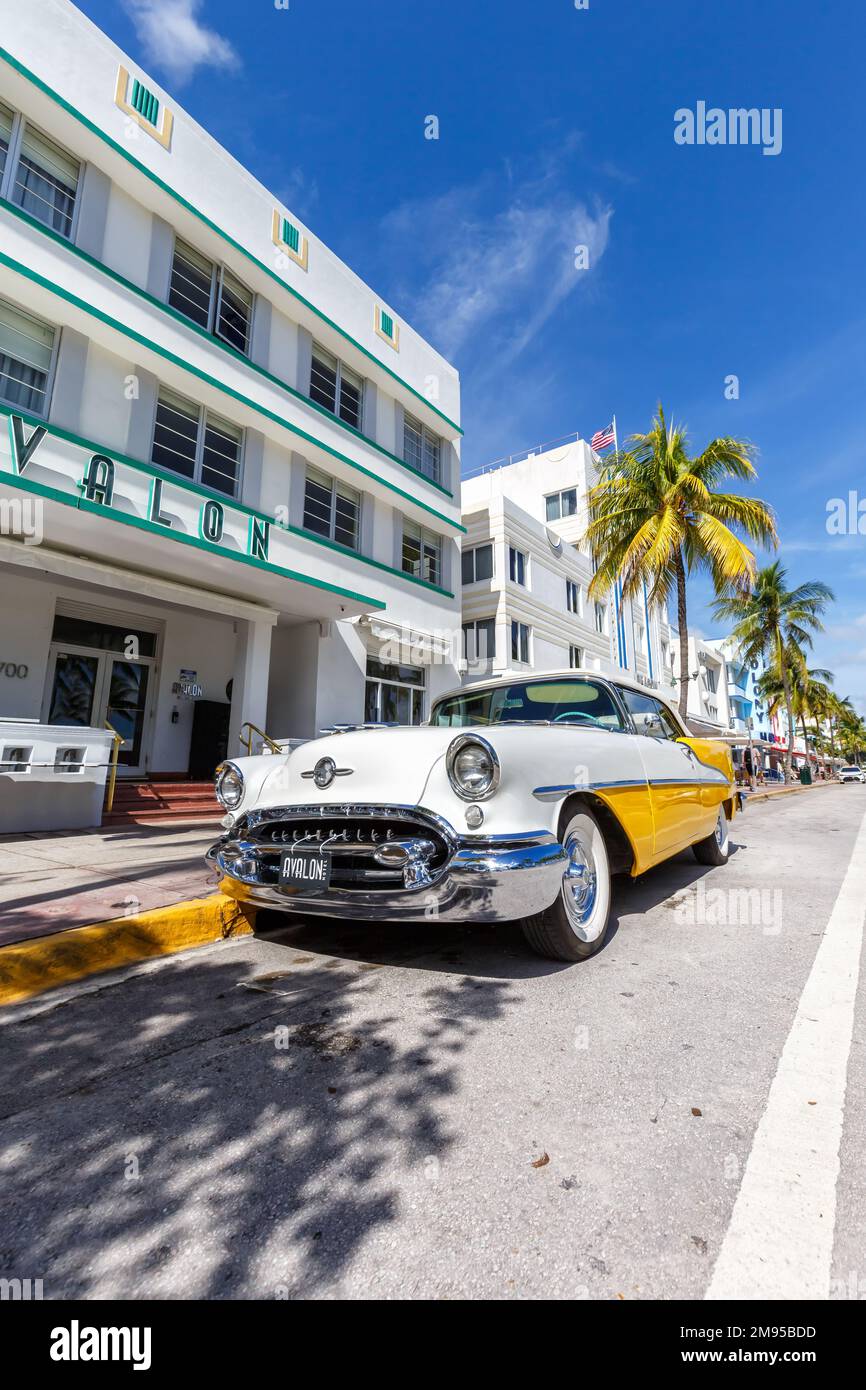 Miami Beach, United States - November 15, 2022: Avalon Hotel in Art Deco architecture style and classic car portrait format on Ocean Drive in Miami Be Stock Photo