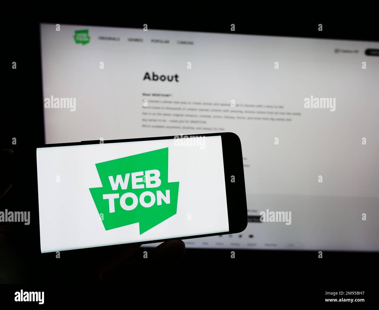 https://c8.alamy.com/comp/2M95BH7/person-holding-smartphone-with-logo-of-digital-comic-company-webtoon-entertainment-inc-on-screen-in-front-of-website-focus-on-phone-display-2M95BH7.jpg