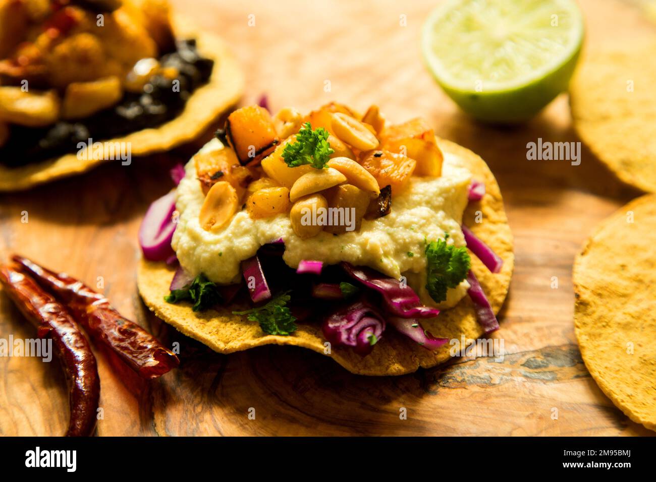 Vegetarian tostadas with hummus. Tostada, name given to various dishes in Mexico that include a toasted tortilla as the main base of its preparat Stock Photo