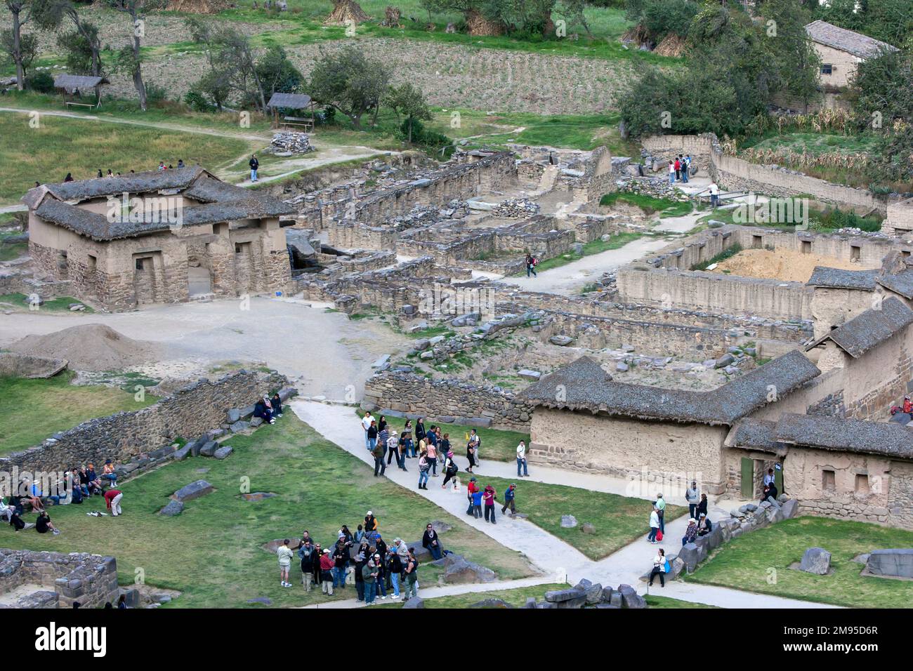 Tourists inspect a section of the ancient Inca ruins adjacent to the ...