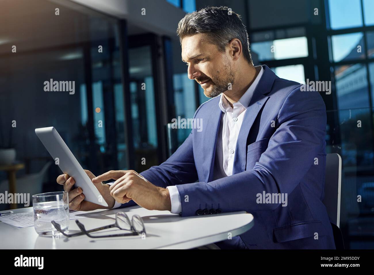 Technology, tablet and businessman online in office with smile checking crypto wallet with internet. Financial trading, cryptocurrency and investment Stock Photo