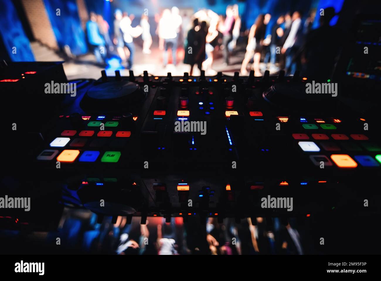 music DJ Desk with blurred background of the dance floor with dancing  people in night club Stock Photo - Alamy