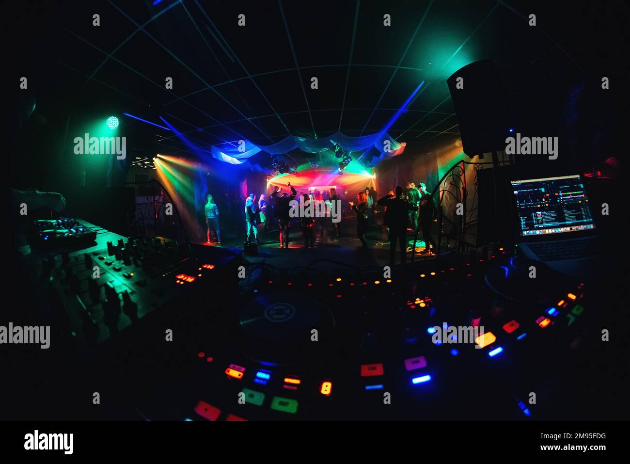dance floor and stage in the night club with a dancing crowd and DJ