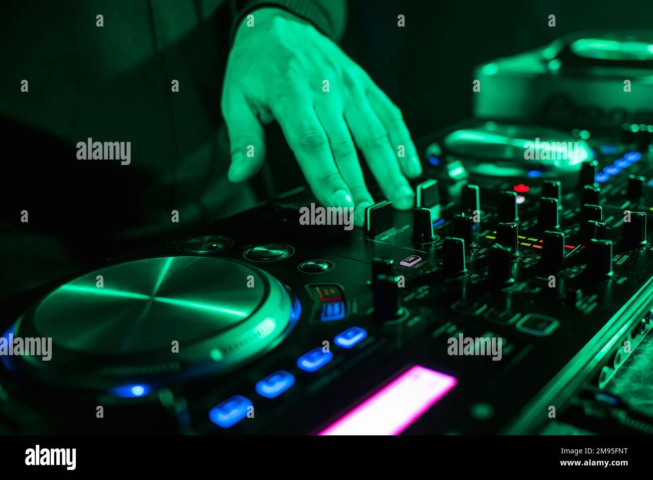 hand moving of the DJ controllers on the music control panel in night
