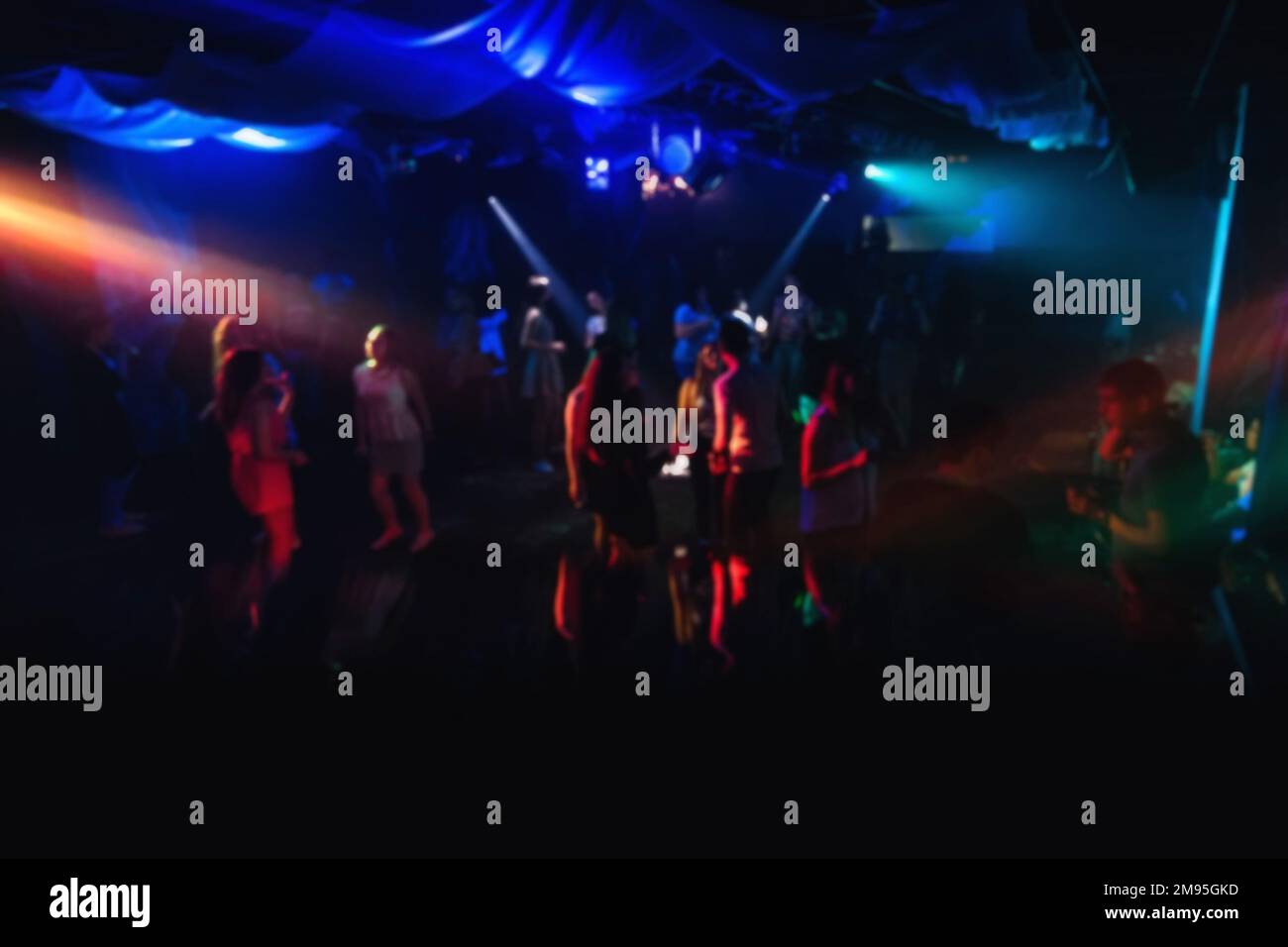 blurred people dancing on the dance floor in a nightclub on the dance floor with colorful background Stock Photo