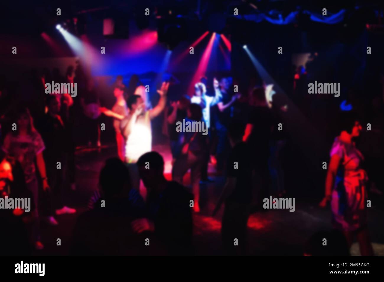 blurred people dancing on the dance floor at a night club concert party