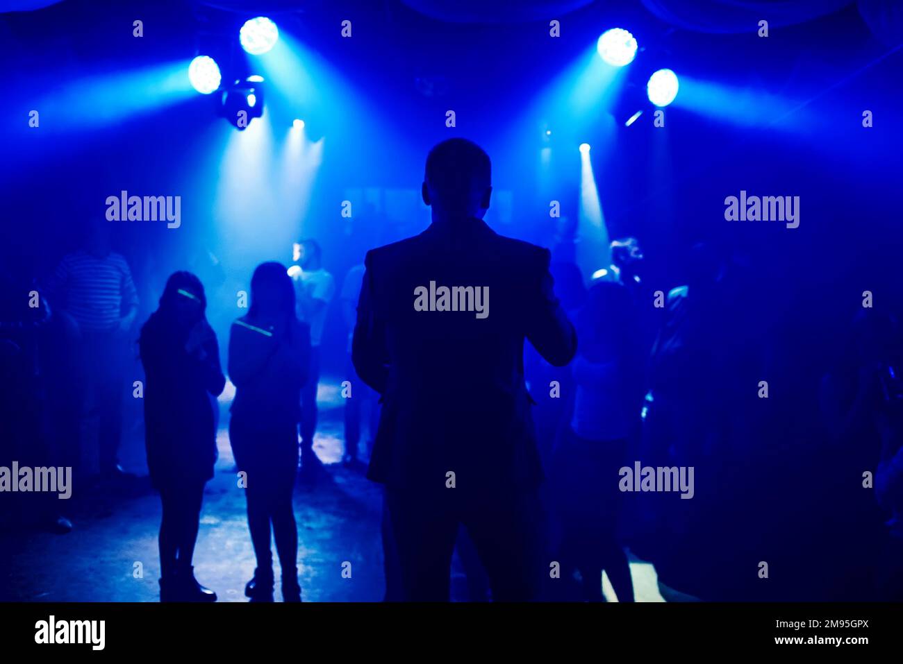 silhouette leading into the nightclub scene with dancing on the dance floor people at the event Stock Photo
