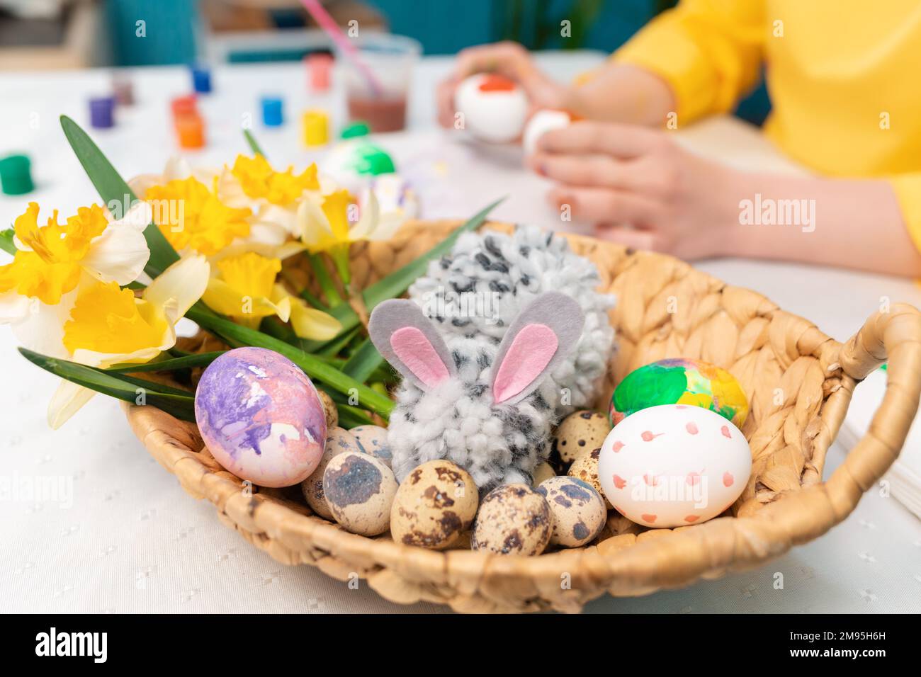 Close up of wicker basket with a toy rabbit, Easter eggs and a ...