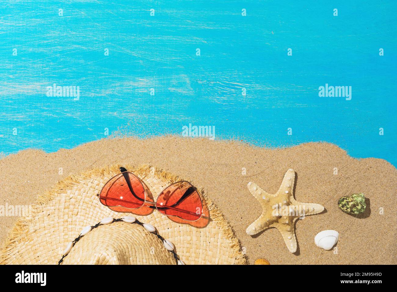 Hat, sunglasses and seashells on the sand with copy space at the top of ...