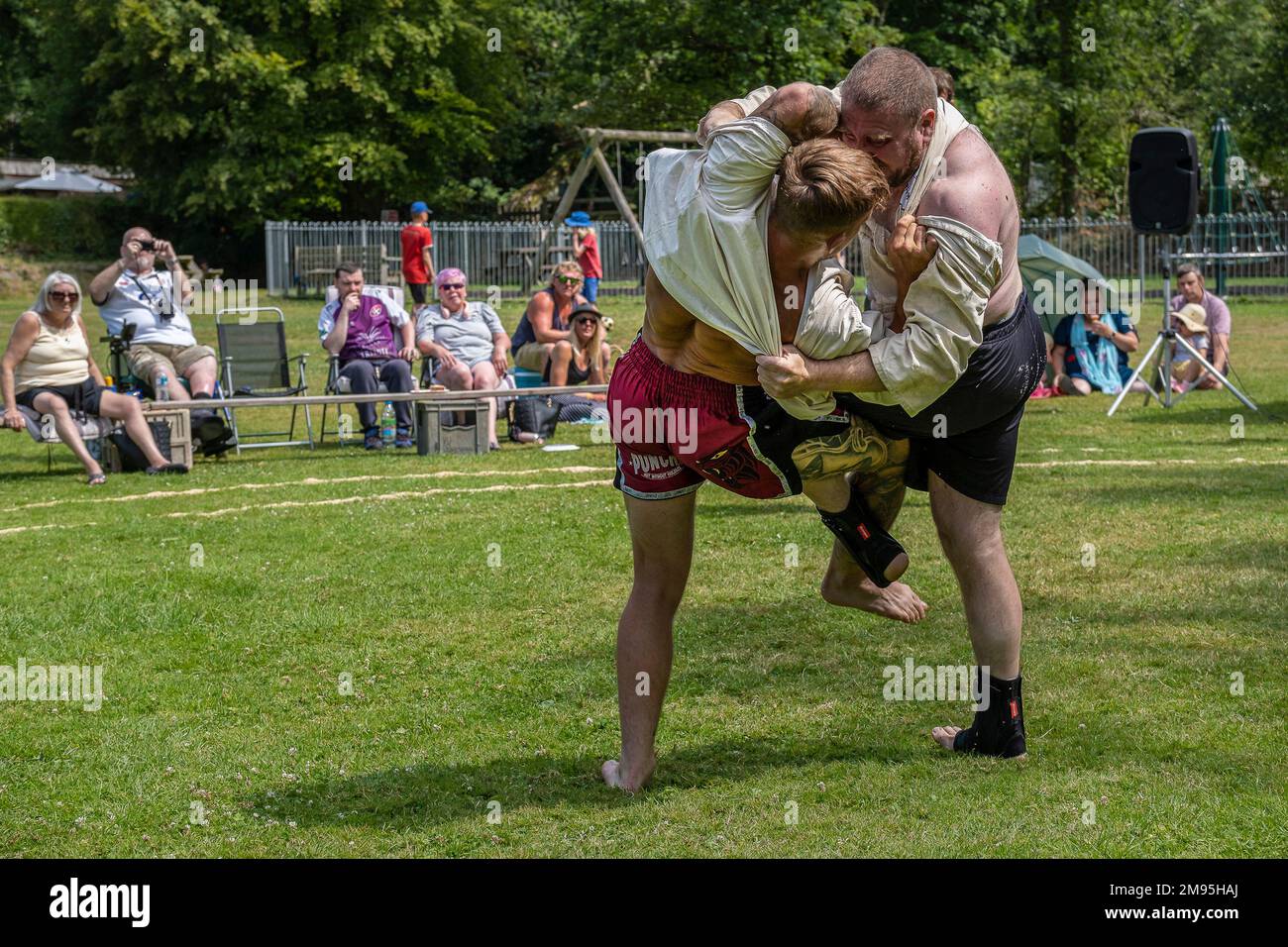 Competitors in the first round of the Mens Open in the Grand Cornish Wrestling Tournament on the picturesque village green of St Mawgan in Pydar in Co Stock Photo
