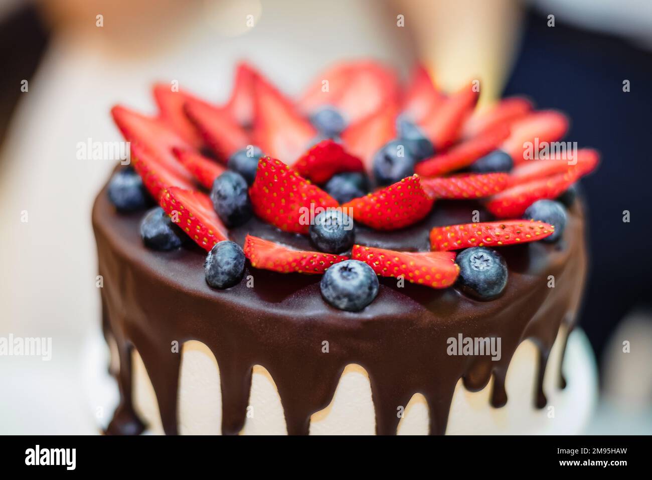 strawberry and bilberry berries on a chocolate icing cake closeup Stock Photo