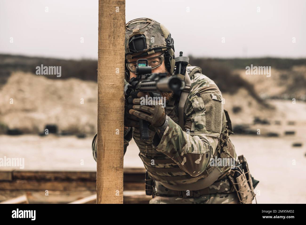 Bearded sniper with optical rifle shooting Stock Photo