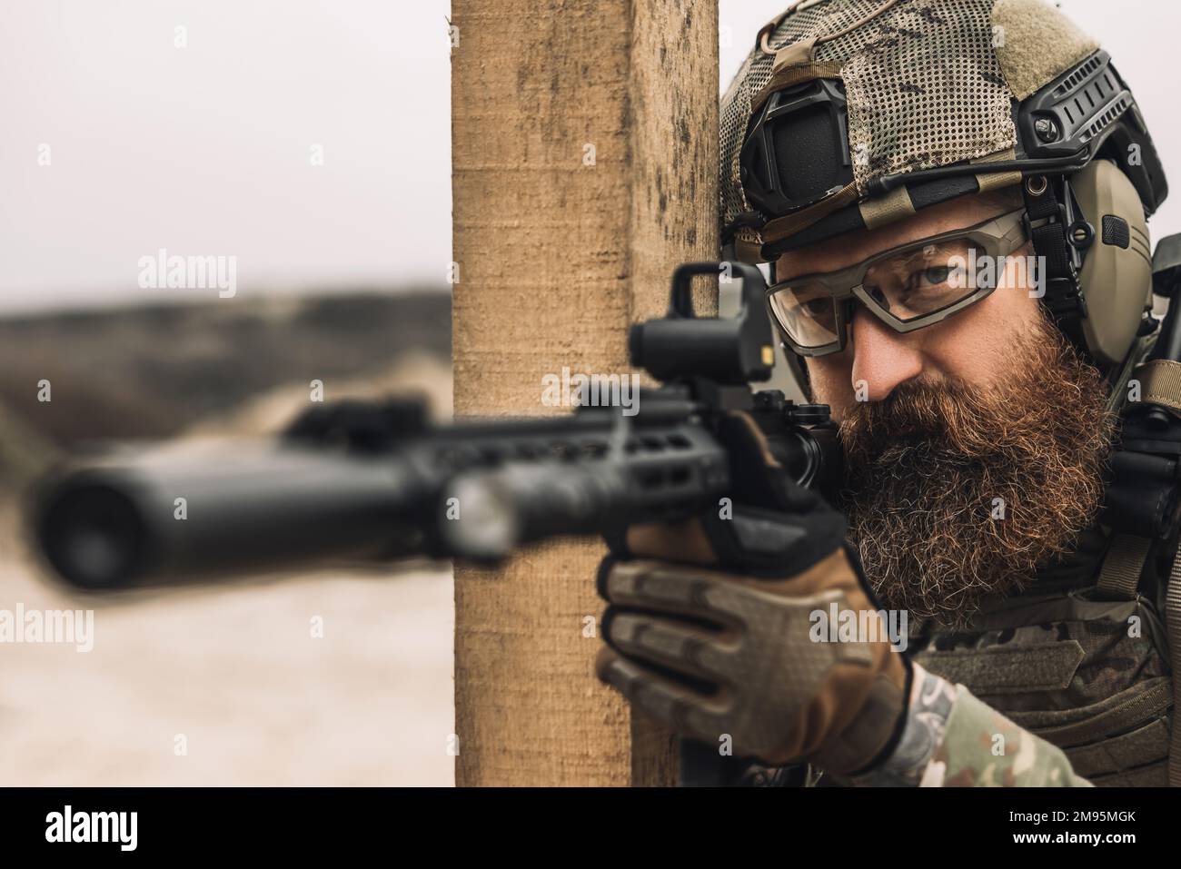 Bearded sniper with optical rifle shooting Stock Photo