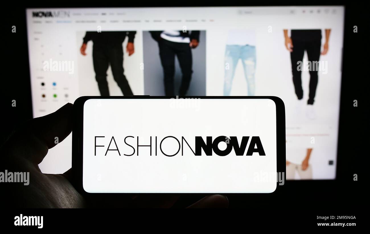 Person holding cellphone with logo of US e commerce company Fashion Nova Inc. on screen in front of business webpage. Focus on phone display Stock Photo Alamy