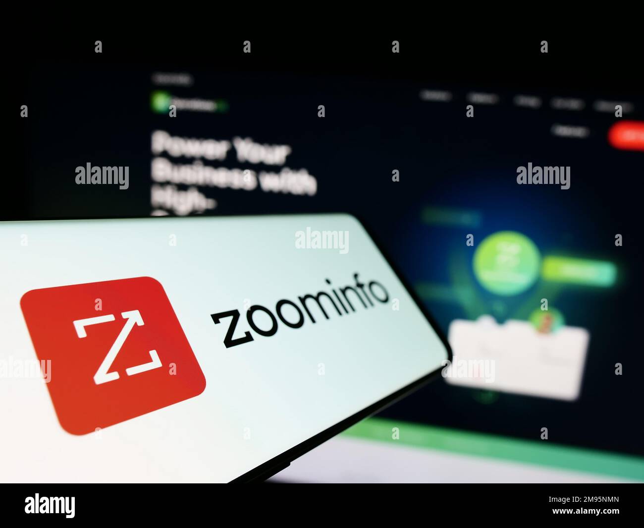 Mobile phone with logo of American software company ZoomInfo Technologies Inc. on screen in front of website. Focus on left of phone display. Stock Photo