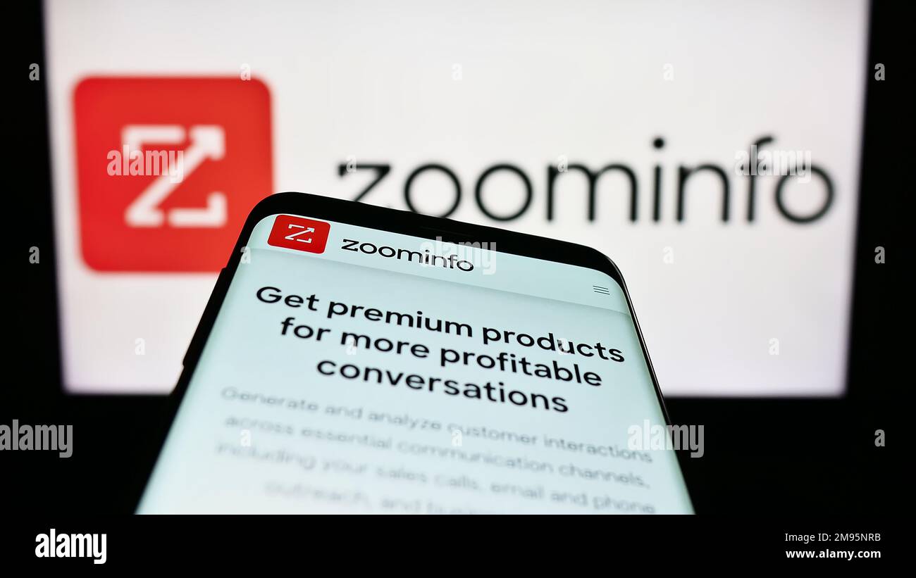 Smartphone with webpage of US software company ZoomInfo Technologies Inc. on screen in front of business logo. Focus on top-left of phone display. Stock Photo