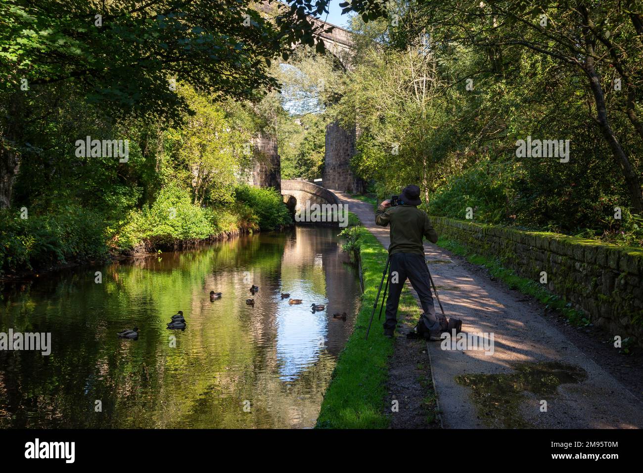 Photographer with tripod on the Huddersfield canal at Uppermill, Greater Manchester, England. Stock Photo