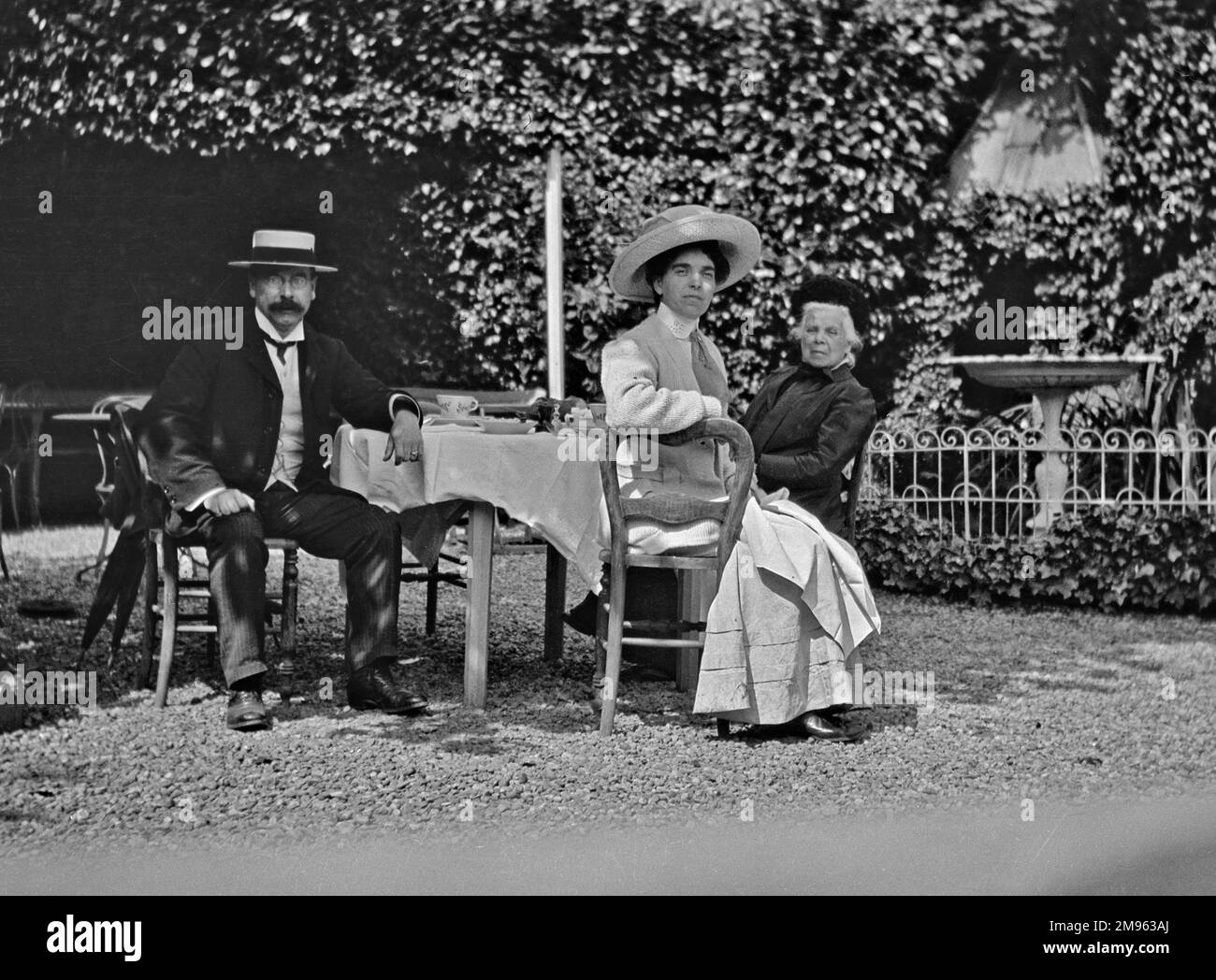 Taking afternoon tea in the shade of a very leafy garden. Stock Photo