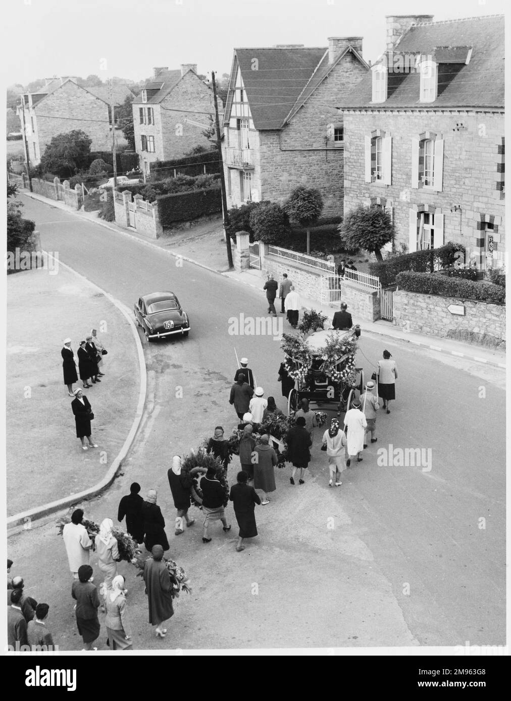 A funeral procession in Ireland. Mourners walk through the streets