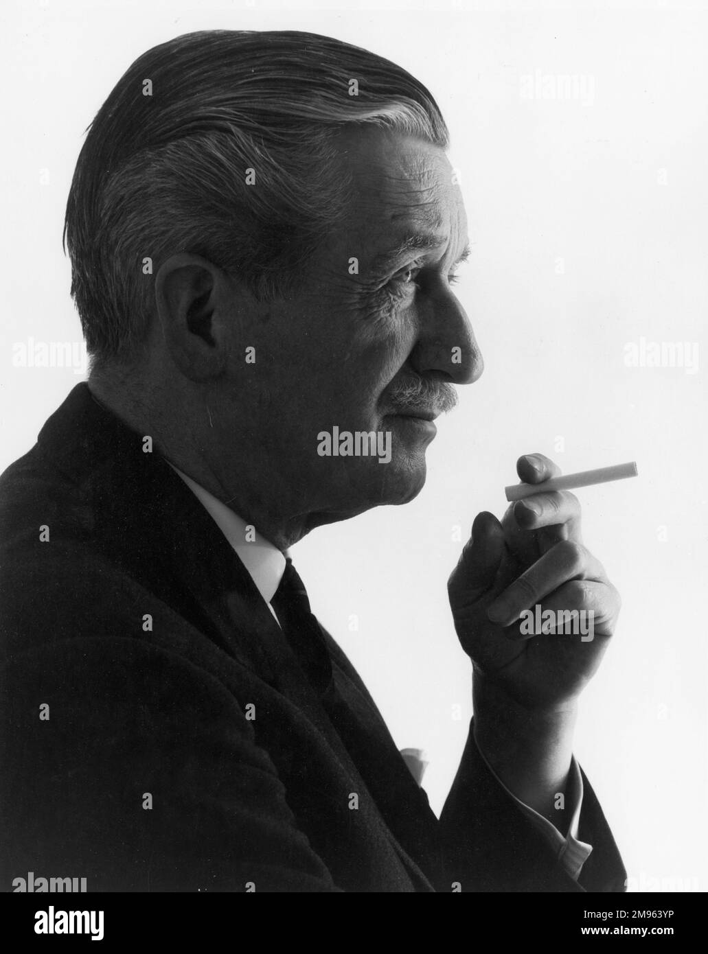 A middle-aged man holds a cigarette Stock Photo