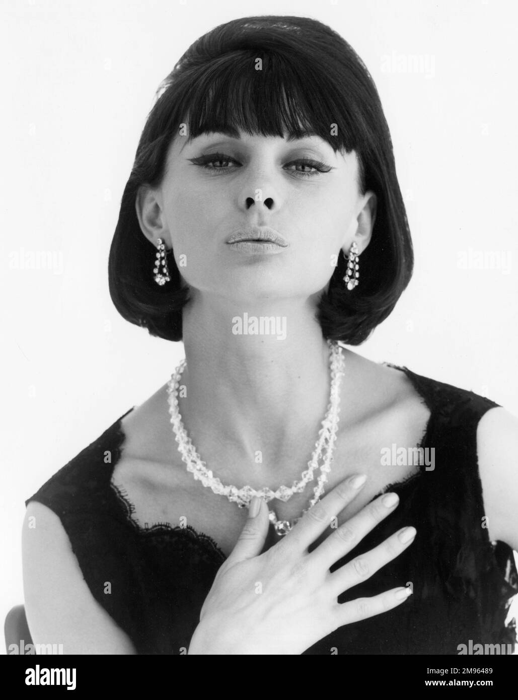 Head and shoulders portrait of a smartly dressed woman pouting in a very Sixties way. Stock Photo