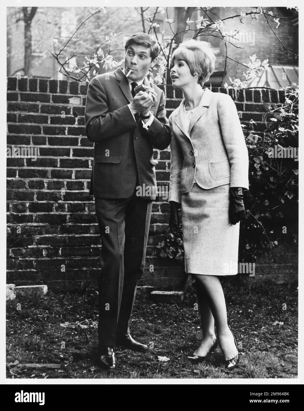 A couple sneak off to a secluded spot for a cigarette Stock Photo