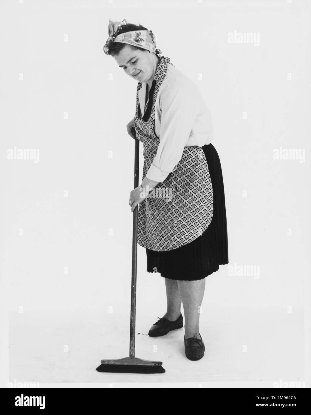 A stereotypical cleaner sweeping the floor. Stock Photo