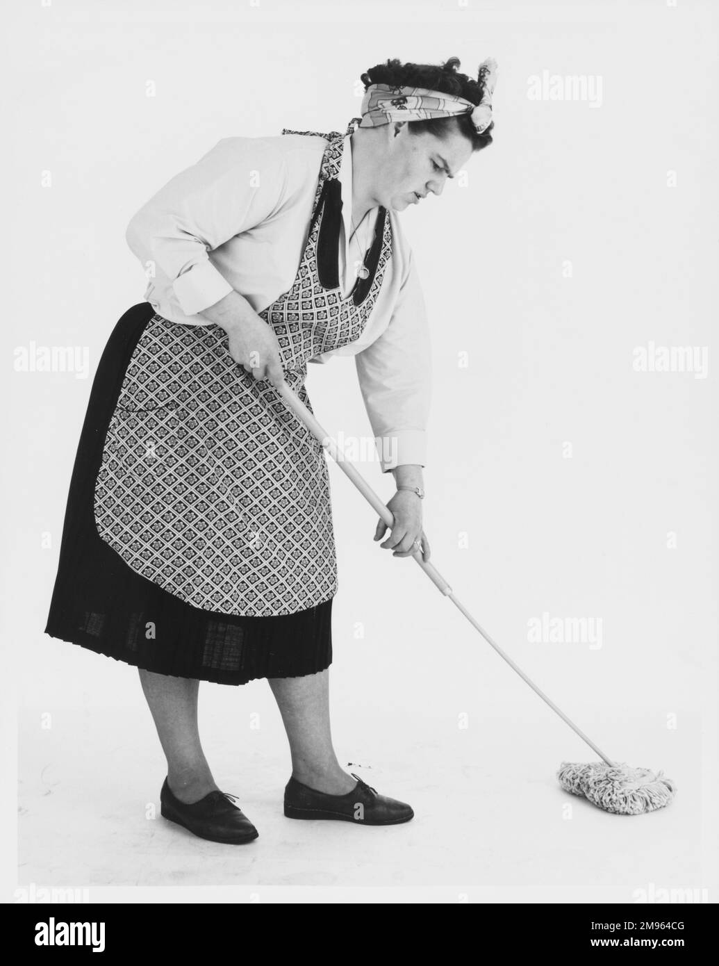 A stereotypical cleaner mopping the floor. Stock Photo