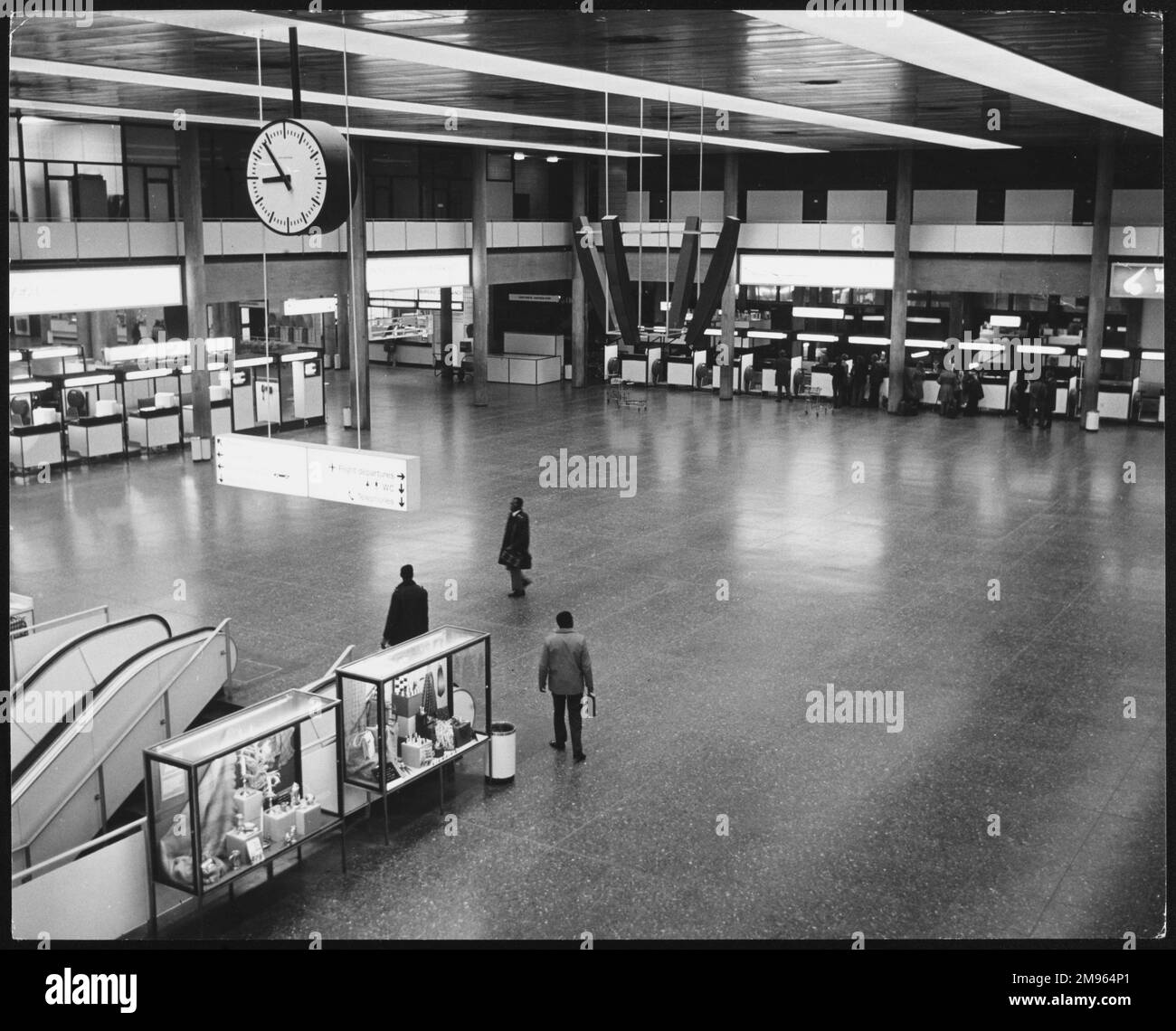 The vast interior of London Gatwick Airport, showing one the escalators beneath the clock. Stock Photo