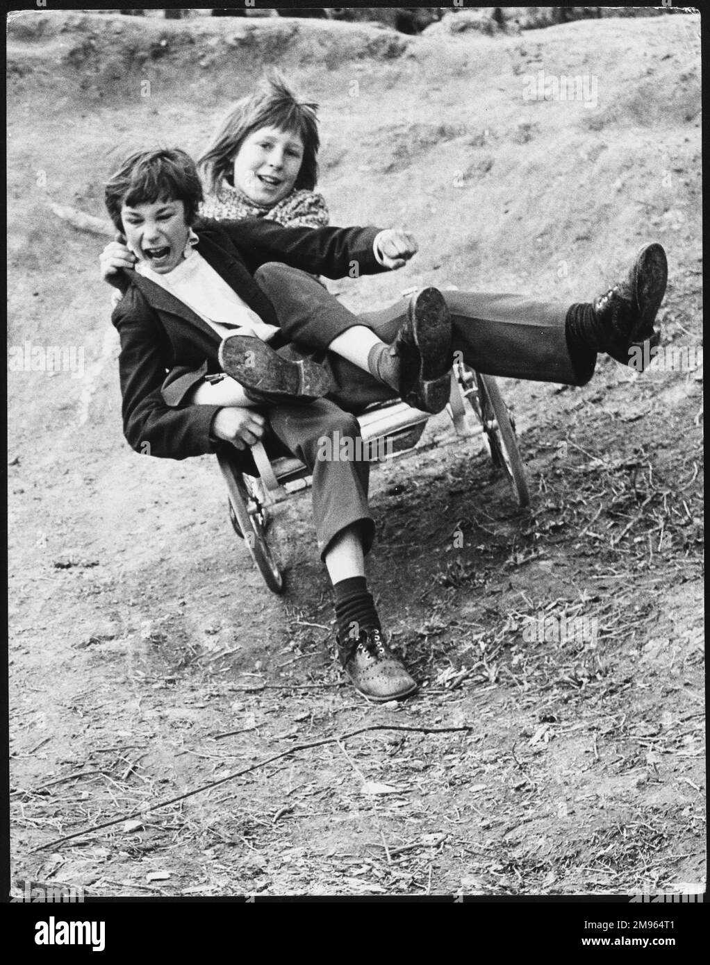 Two boys messing about on a go-cart on Horley Recreation Ground, Surrey, England. Stock Photo