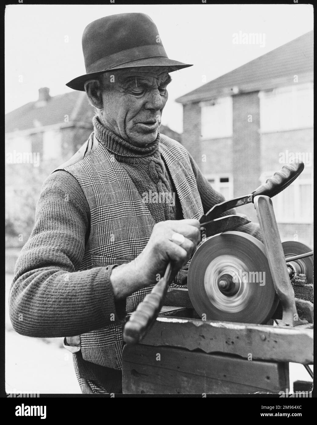 Henry Jones, mobile grinder, sharpening a knife at his grindstone