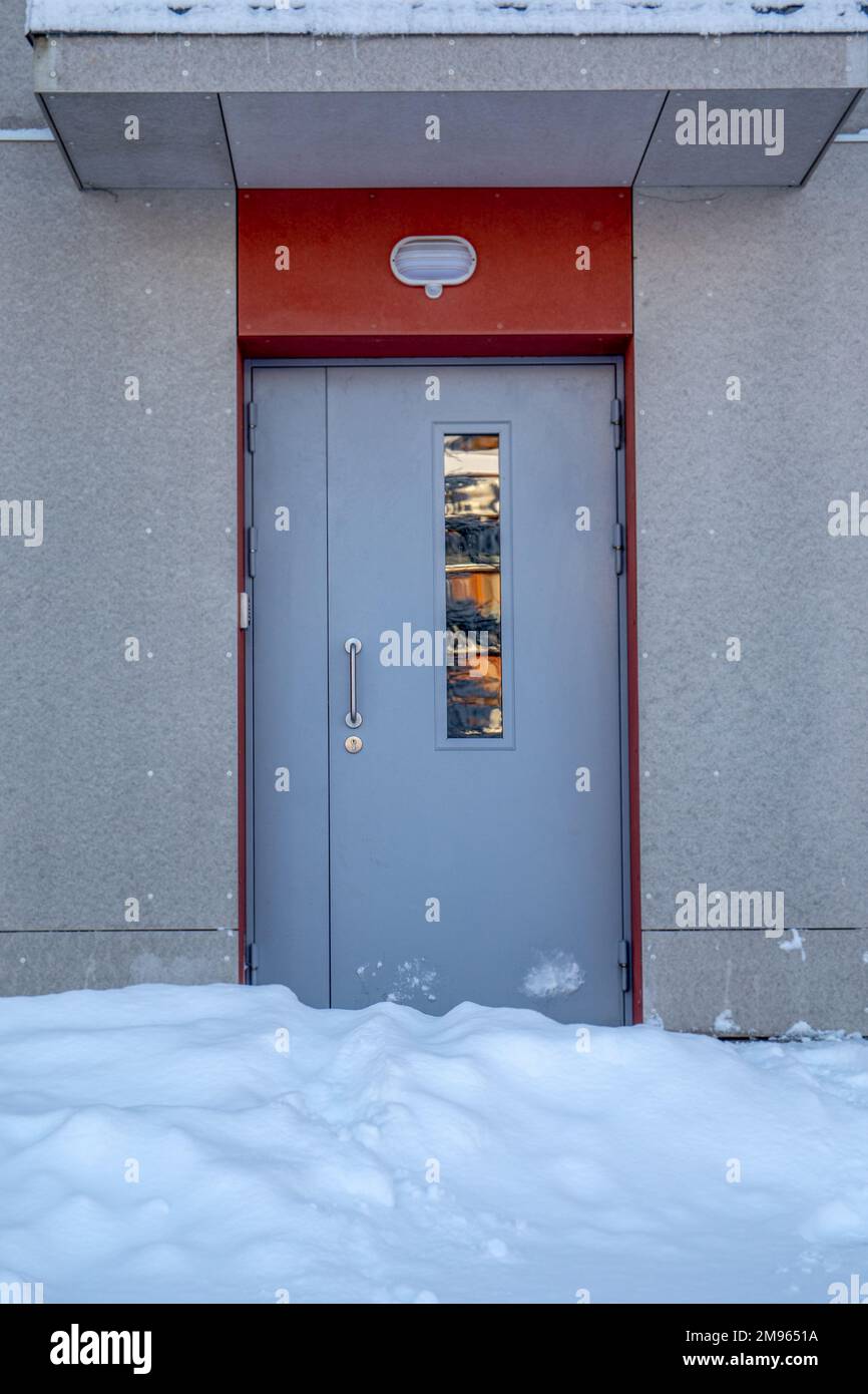 Front door of the apartment building covered with snow. Snowfall and storm. Stock Photo