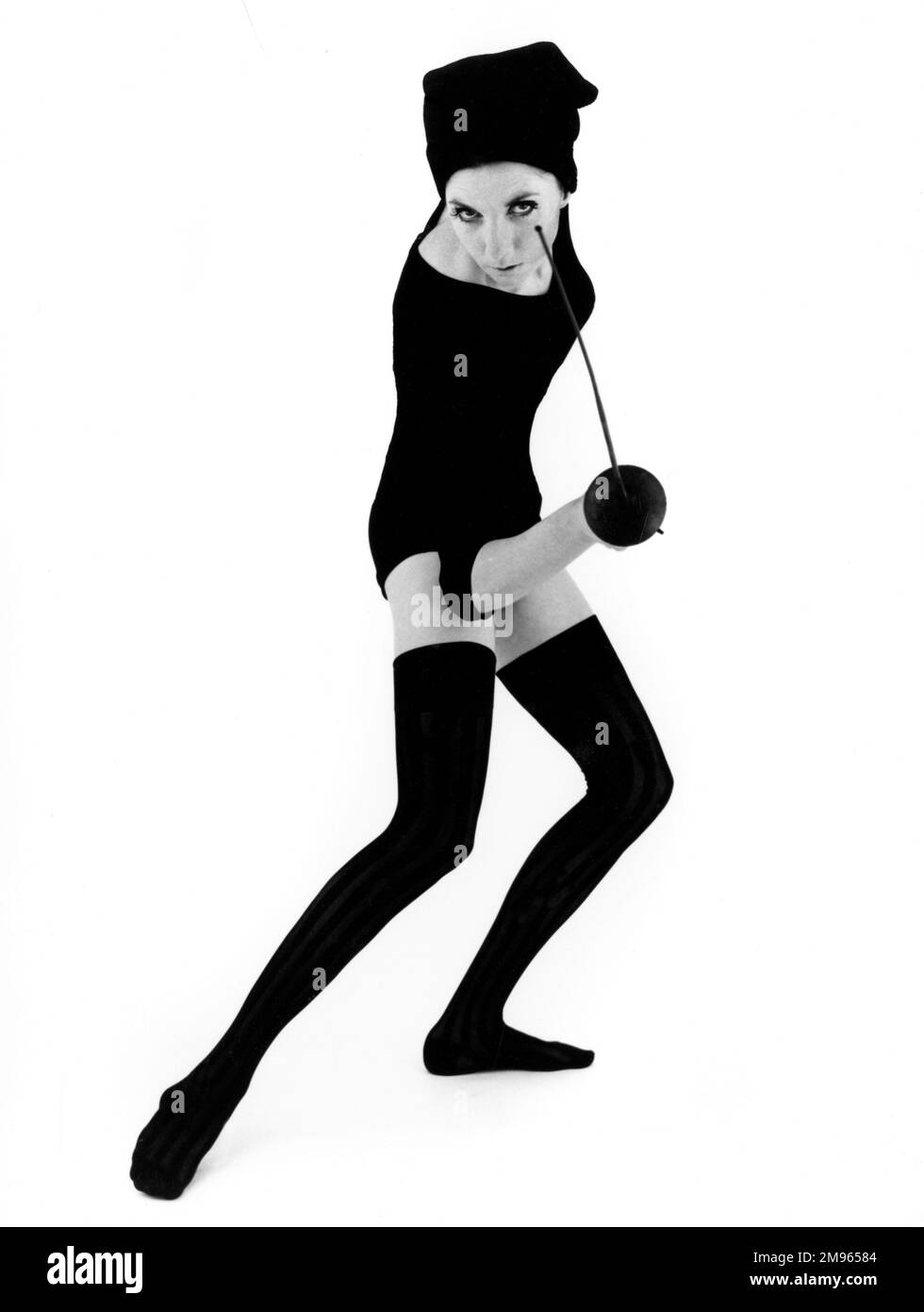 A woman poses in a leotard holding a fencing foil. Stock Photo