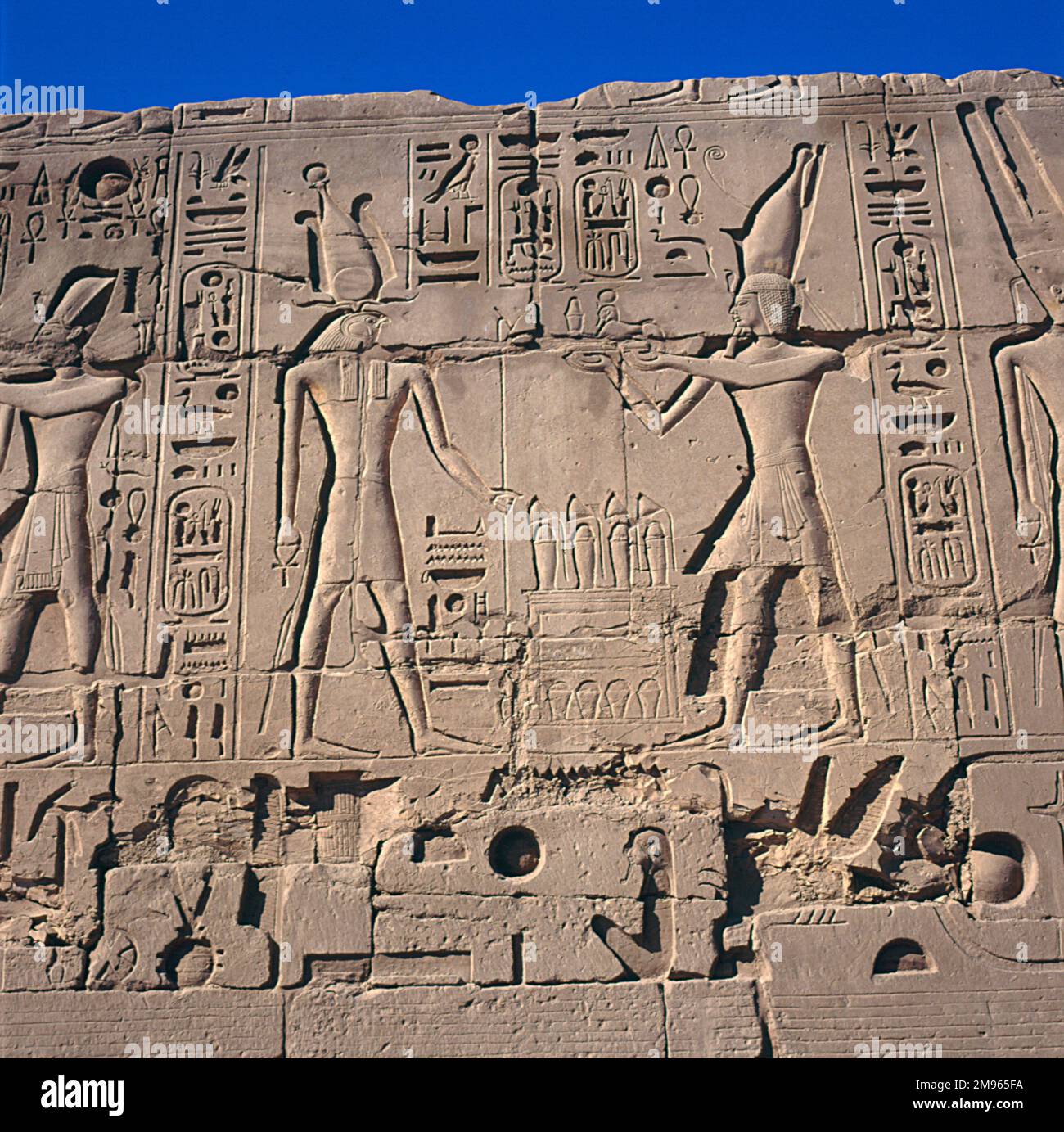 Relief at the east side of the 4th Pylon of Thutmosis I, showing the god Amun Re (left), Rameses II (centre) and Osiris (right), Karnak Thebes (modern Luxor), Egypt. Stock Photo