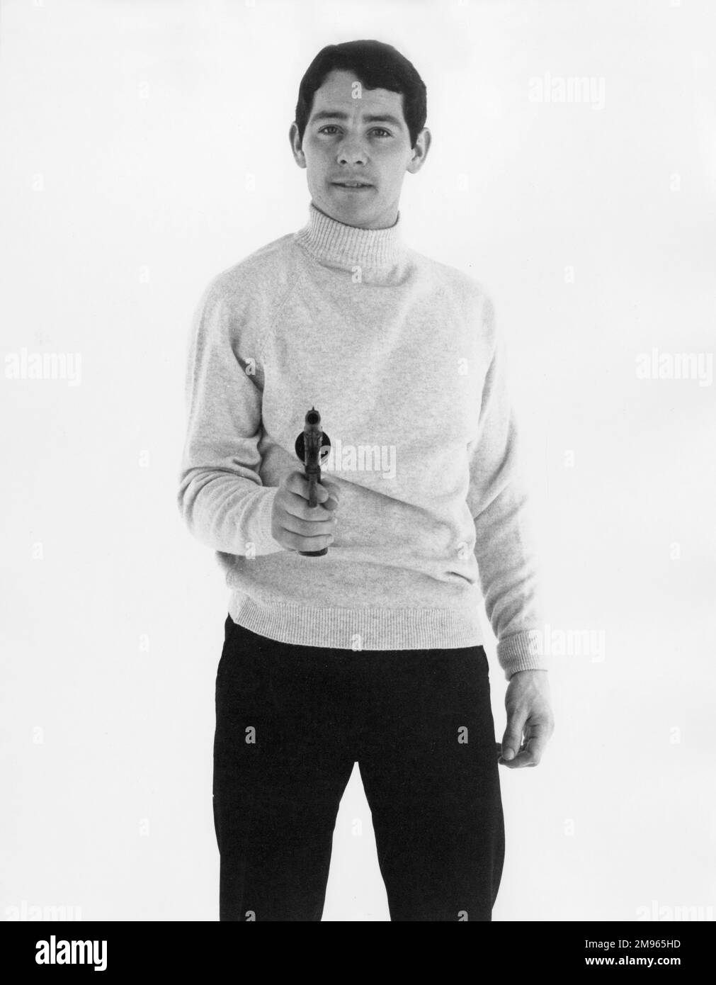 A male model points a gun at the camera Stock Photo Alamy