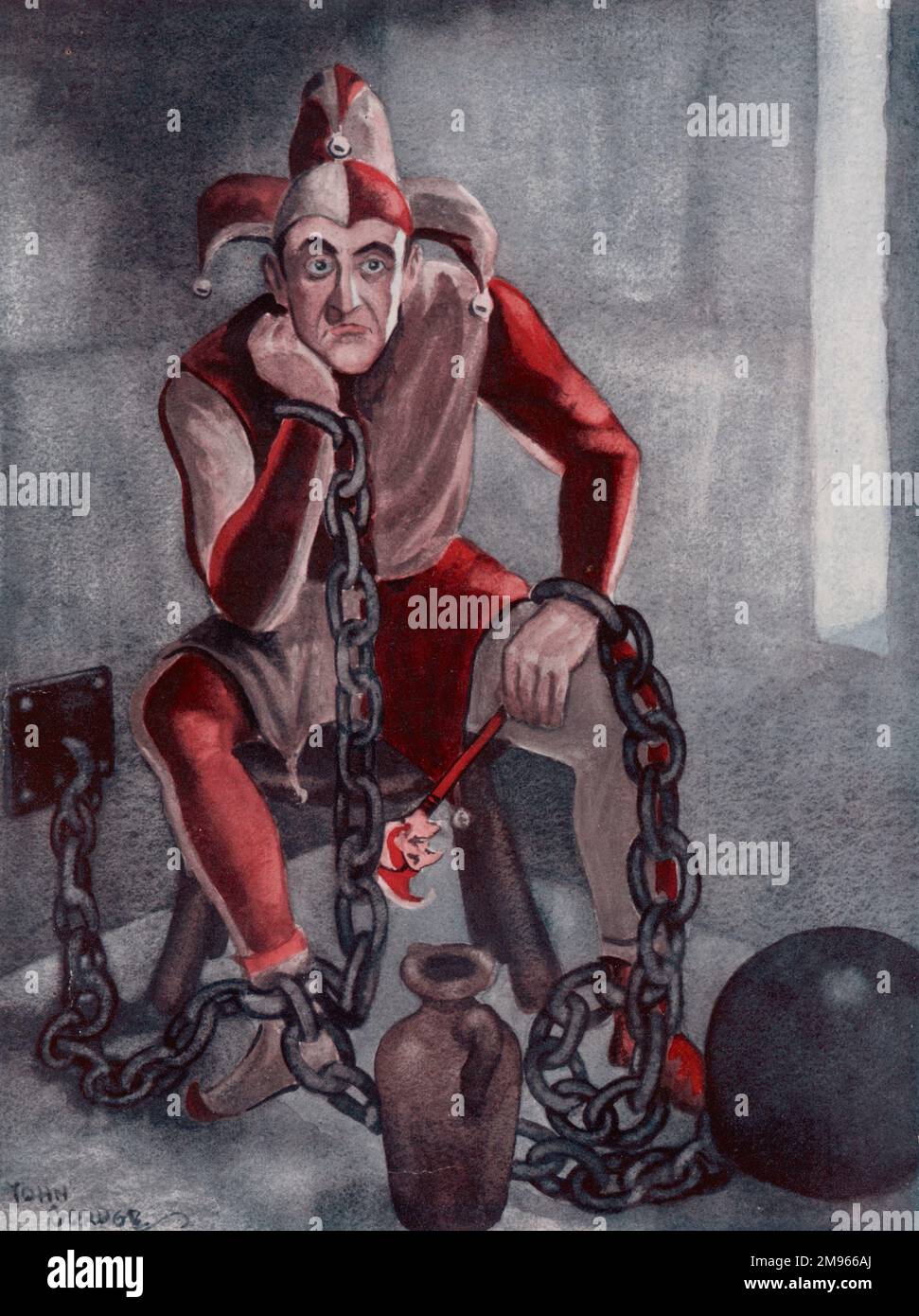 A glum looking jester sits in a prison cell attached to a ball and chain. Stock Photo