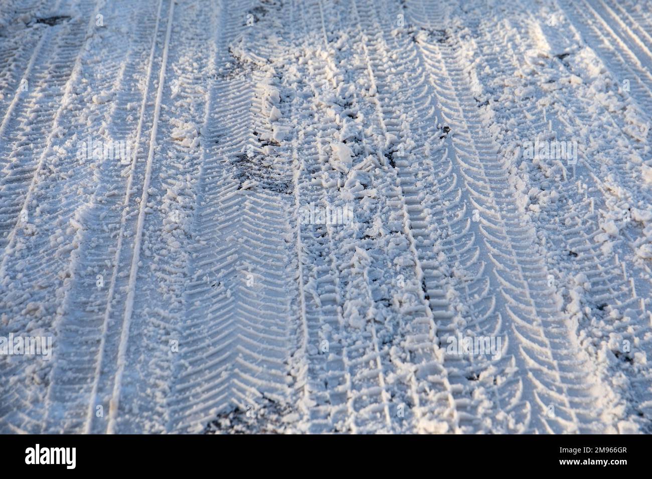Car tire tracks. Snowy and icy road, dangerous and unsafe. Black ice