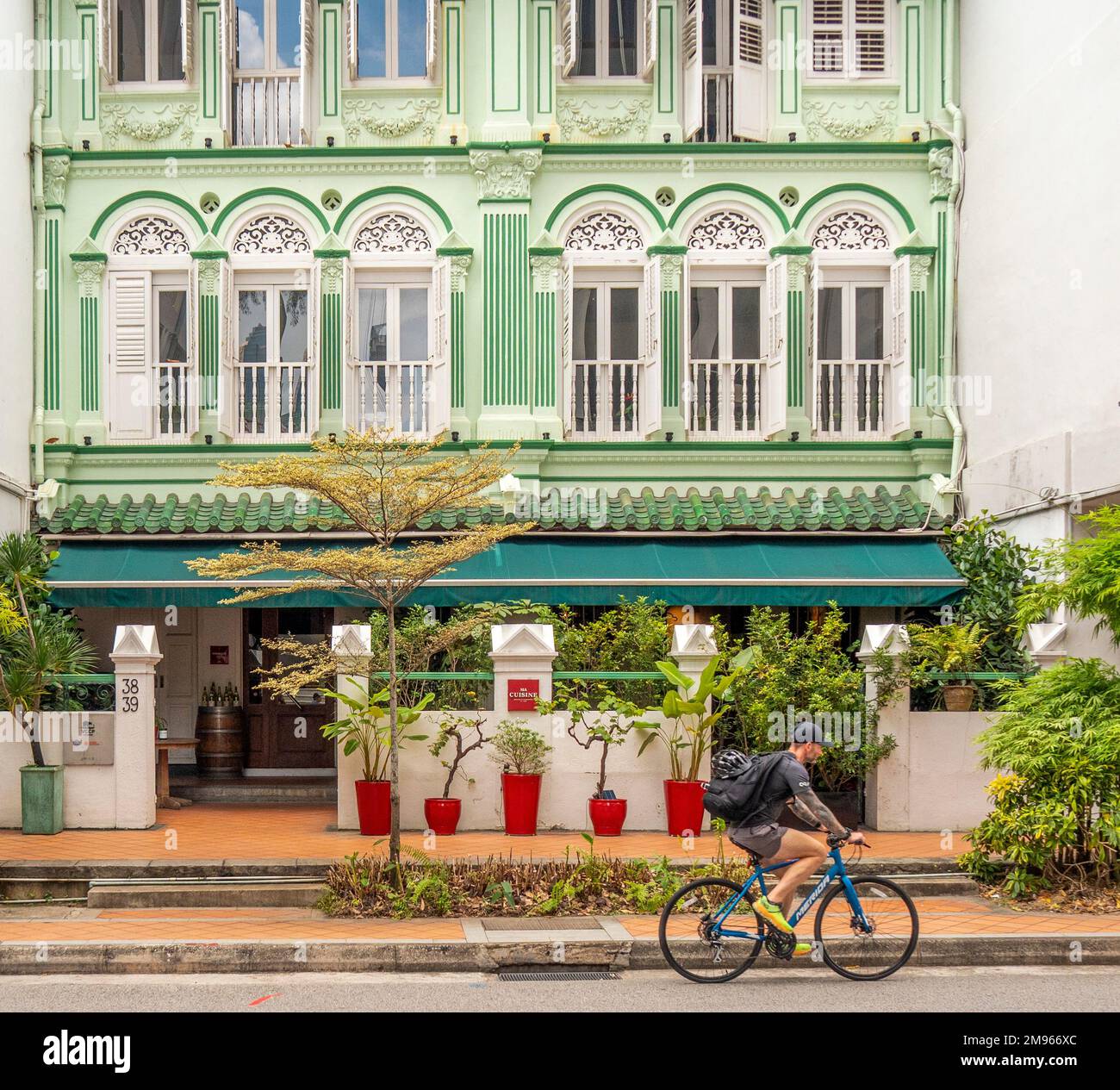 Cyclist riding bicycle pass terraced shophouses converted into a restaurant on Keong Saik Rd Chinatown Singapore Stock Photo