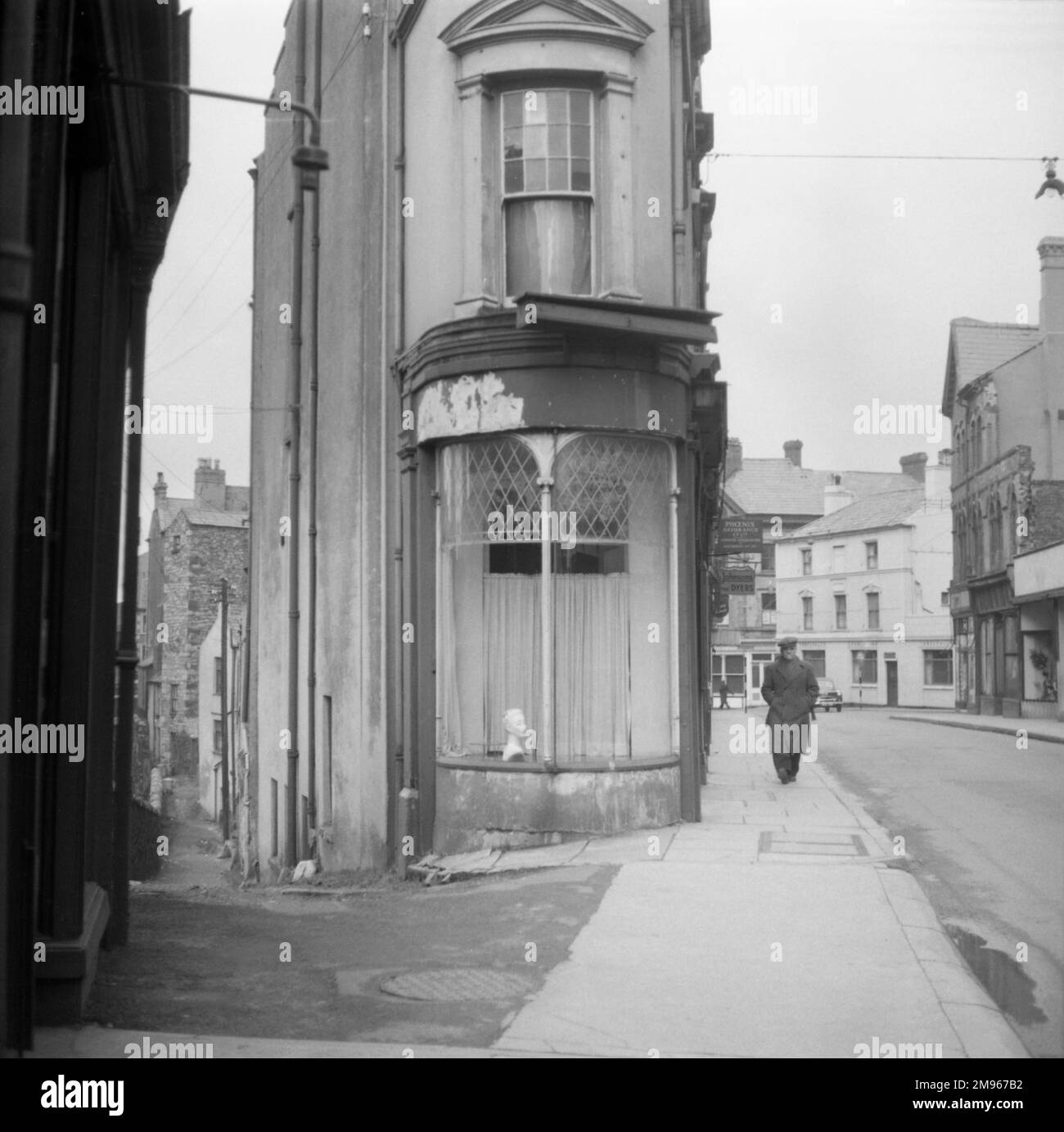 The elegant curved front window of a very narrow house at the end of two diverging streets in Wales. Photograph by Norman Synge Waller Budd Stock Photo