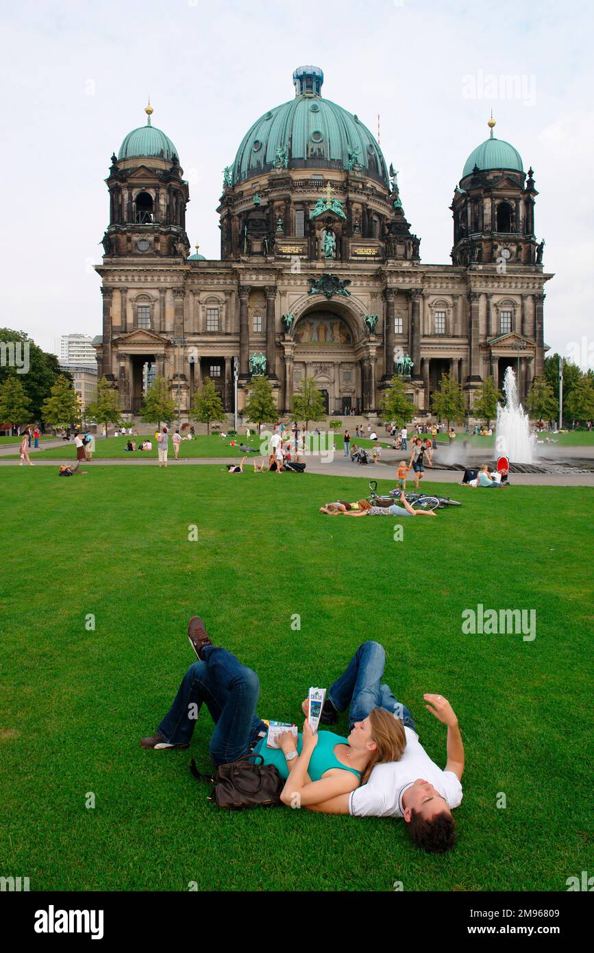 Visitors relax on the grass in front of Berlin Cathedral, Germany. Stock Photo
