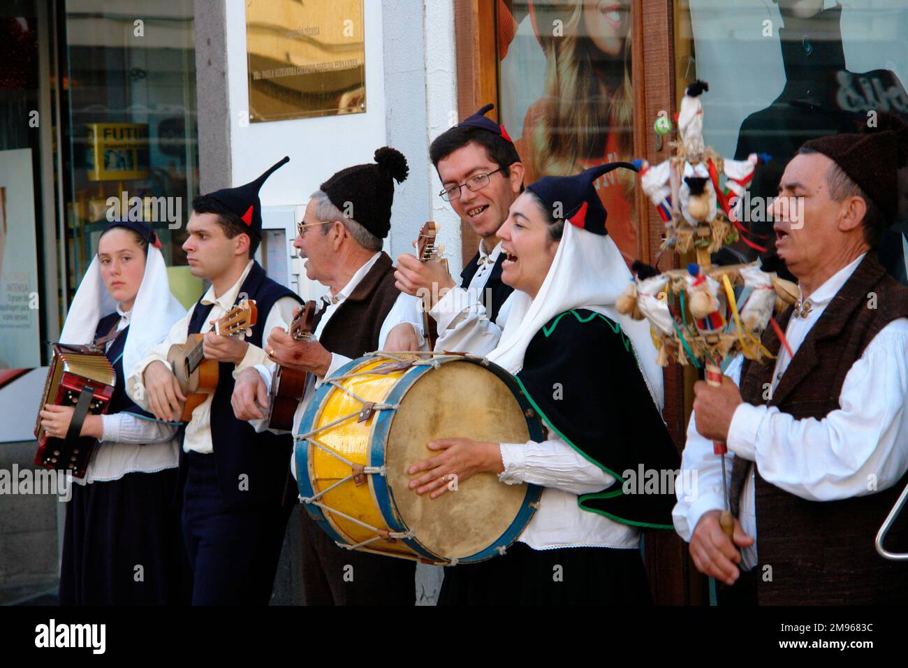 A traditional Boa Nova folk group playing musical instruments and singing, seen in Funchal, the capital city of Madeira.  The man on the right is holding a percussion instrument known as a brinquinho, a stick decorated with wooden dolls, bells and castanets, which is shaken up and down. Stock Photo