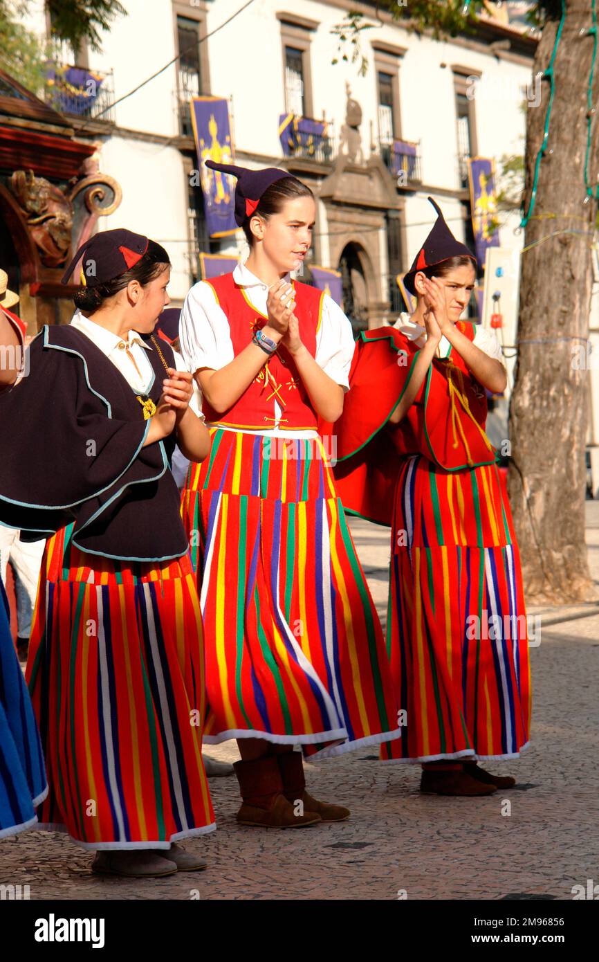 Three girls from a folklore group from the village of Camacha, seen here in Funchal, the capital city of Madeira.  They appear to be clapping in time to music. Stock Photo