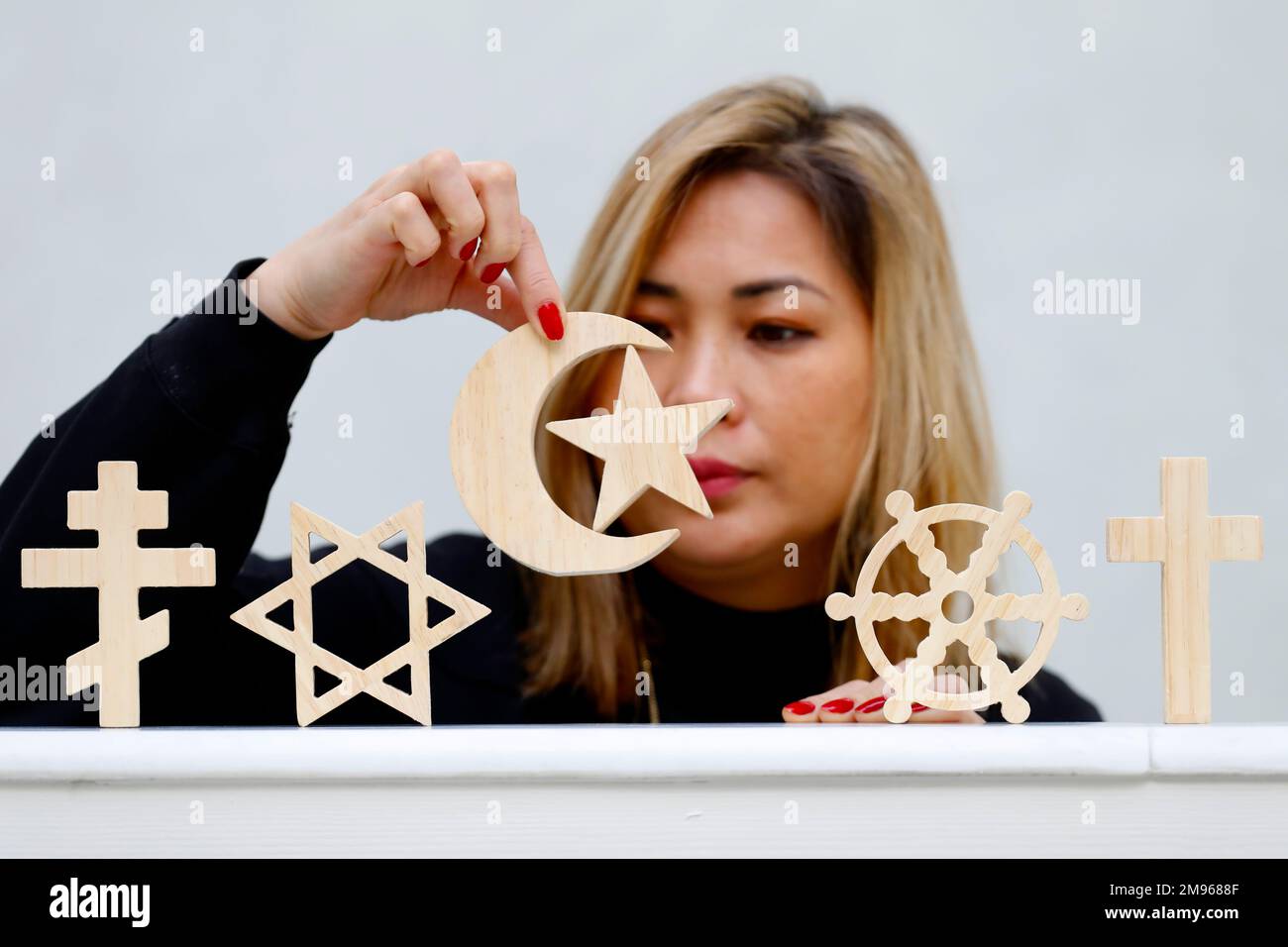 Woman with wooden religious symbols Catholic, Islam, Judaism, Orthodox, Protestant, Buddhism