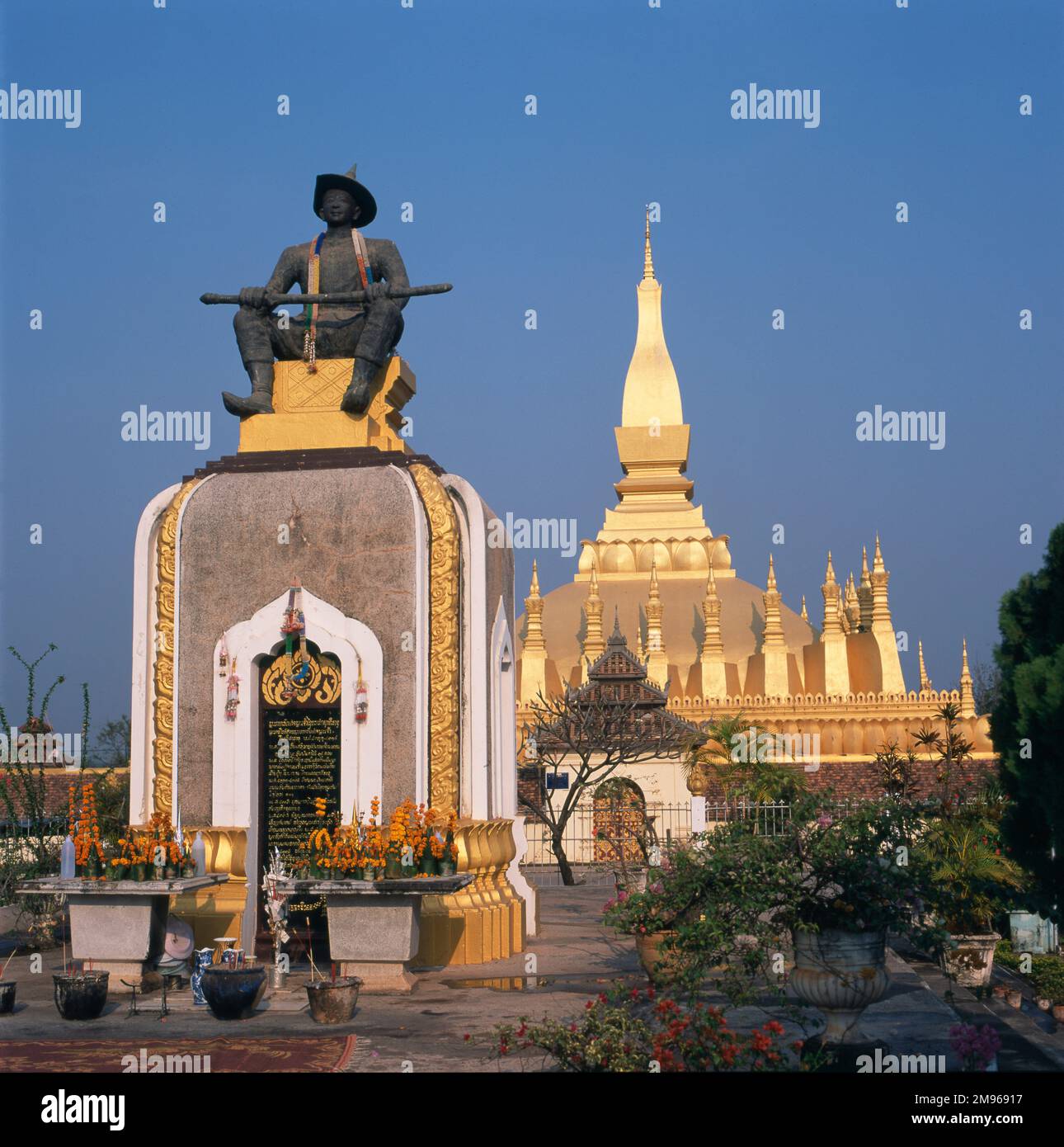 Monument to King Setthathirat (ruled 1559-1571) of Lan Xang (left), with the golden stupa of That Luang Wat Buddhist Temple (right), at Vientiane, Laos. Stock Photo