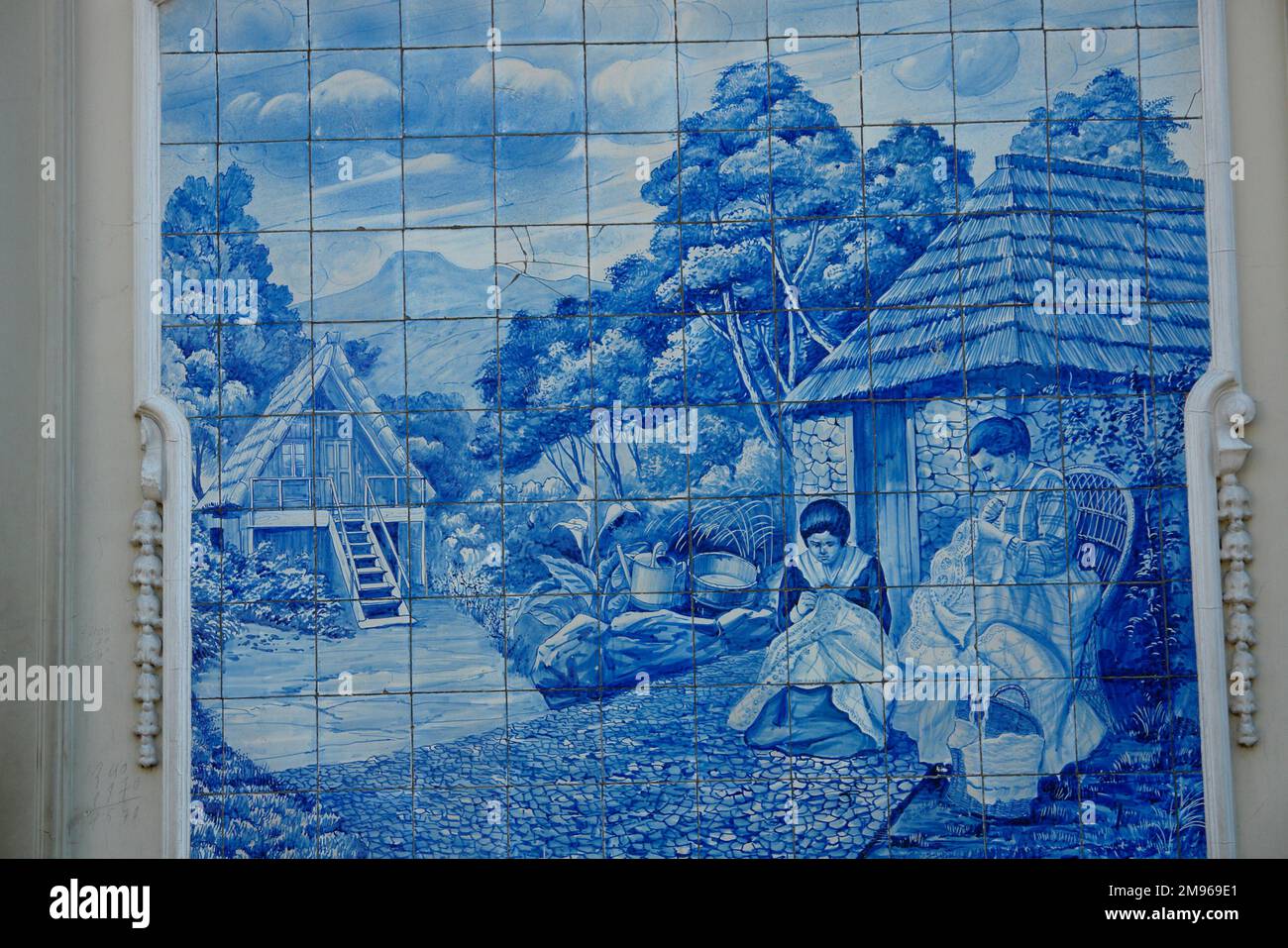 A picture on blue tiles outside the former Ritz Cafe, in the Avenida Arriaga in Funchal, Madeira, Portugal. This type of traditional design, on blue and white tin-glazed ceramic tiles, is known in Spain and Portugal as azulejo or azulejos. Stock Photo