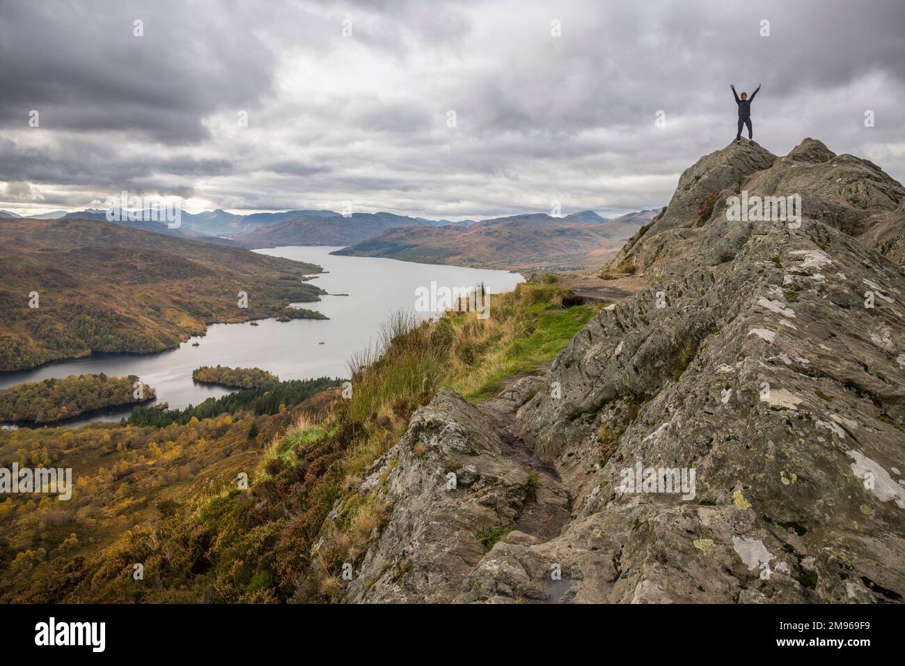 Walkers at the summit of Ben A'an, looking towards Loch Katrine, Loch Lomand and Trossachs National Park, Scotland Stock Photo