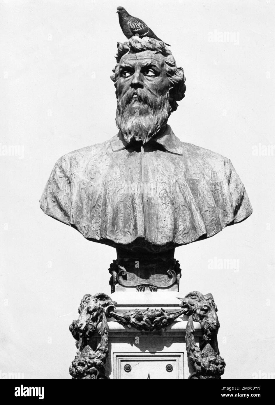 A portrait bust on Benvenuto Cellini (1500-1571), celebrated Italian goldsmith, sculptor, painter, soldier and musician, on the Ponte Vecchio in Florence, Italy, with a pigeon perched on its head. Stock Photo