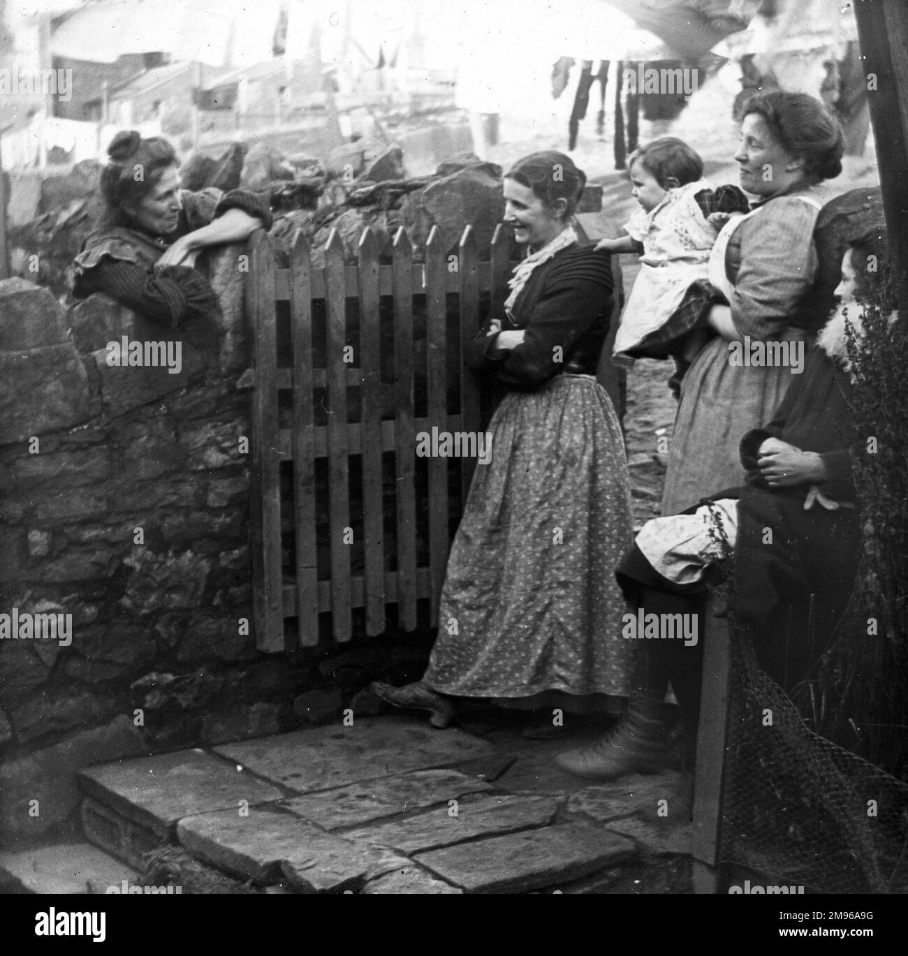 A group of women, probably all wives of coal miners, chatting in the back yard of 76 Hanbury Terrace, Pontypool, South Wales.  The smiling woman in the spotted skirt is the mother of W E Jones. Stock Photo