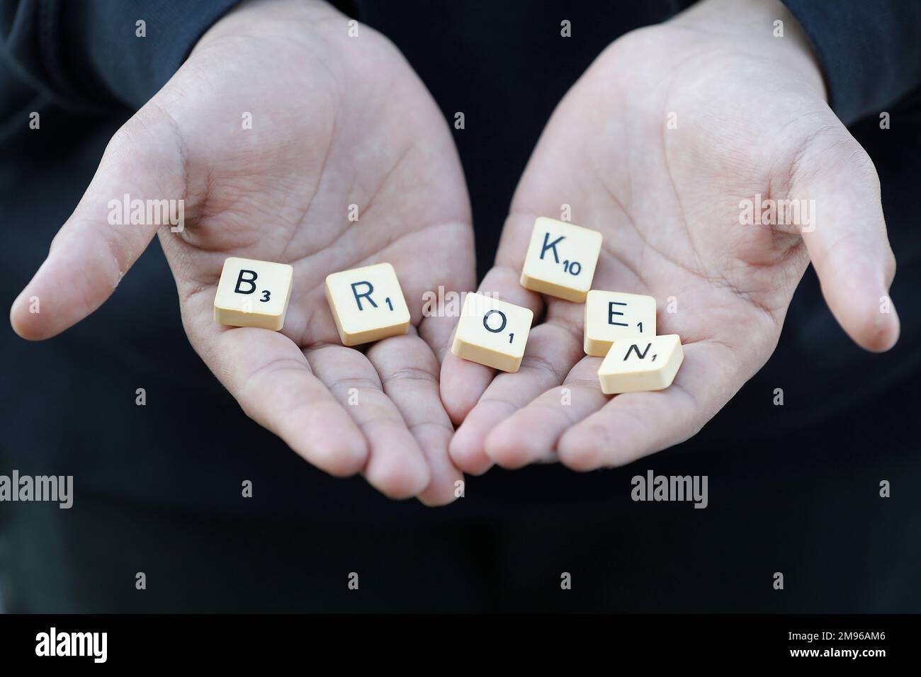 Boy showing letters spelling broken in Eure, France Stock Photo